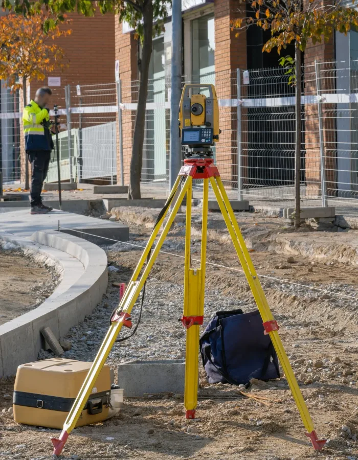 Surveyor with total station equipment on a construction site